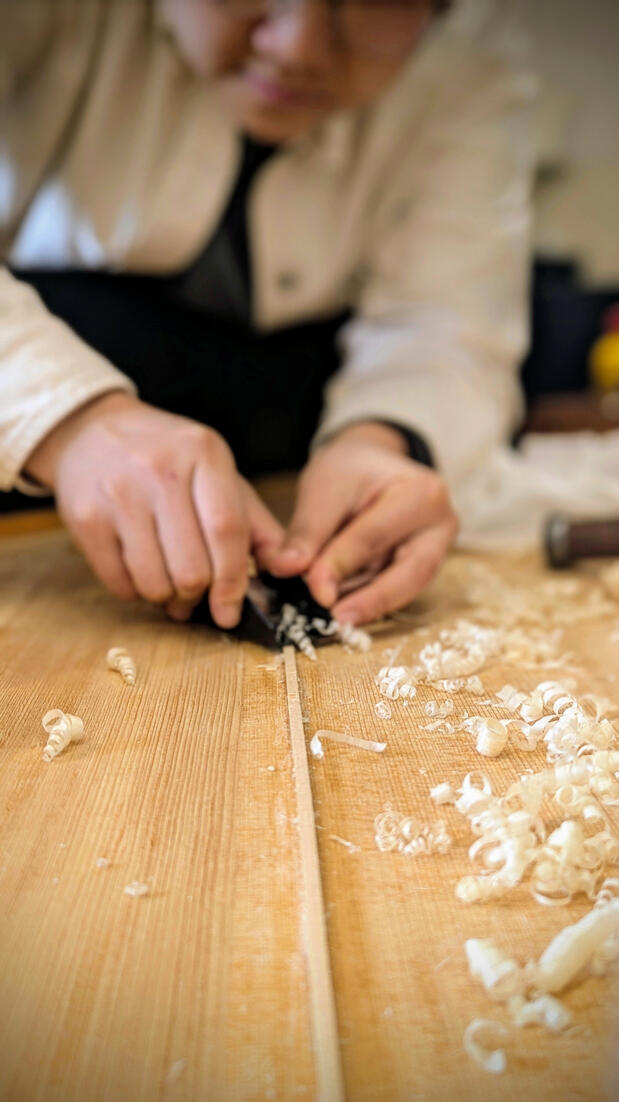 After glue has cured, custom-cut spruce shims are trimmed flush and hand-sanded to match the soundboard’s original contour. This precise soundboard repair eliminates structural buzzing and allows for a seamless finish, preserving the instrument's authentic