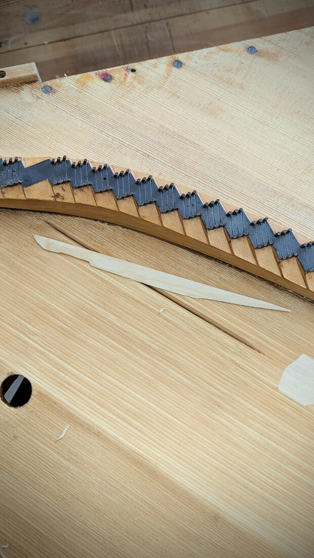 Piano soundboard repair involves cleaning and filling cracks with custom spruce shims to restore structural integrity and tonal resonance. This critical piano restoration process eliminates structural buzzes and preserves the legendary sustain and projecti